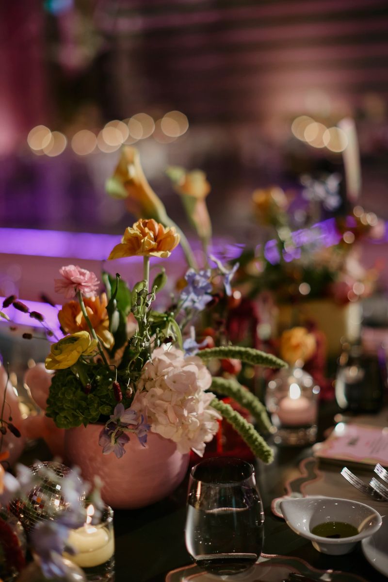Beautifully styled wedding reception table featuring vibrant floral arrangements, soft candlelight, and elegant table settings. The shallow depth of field and warm ambient lighting create a romantic and festive atmosphere, ideal for concepts such as wedding celebration, luxury events, fine dining, party décor, romance, and special occasions. stock photo