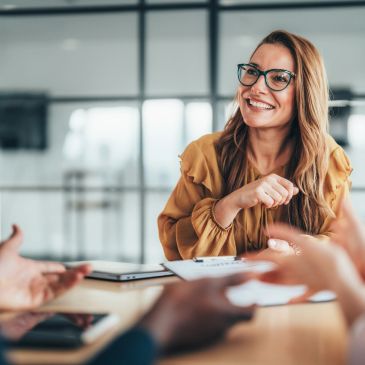 Smiling woman in glasses engaged in a meeting.