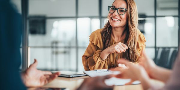Smiling woman in glasses engaged in a meeting.