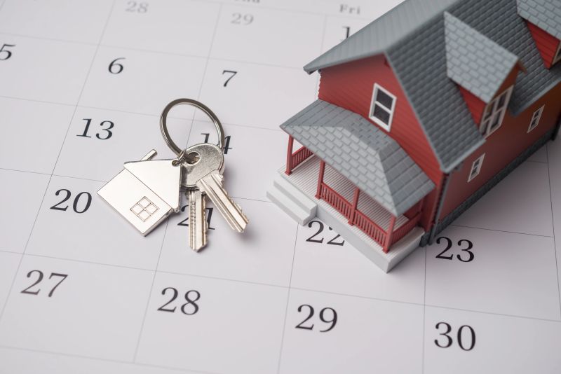 House model and key on white calendar background. Mortgage loan for buying home or real estate property, home finance, money saving planning, money risk management, installment schedule and so on concept.