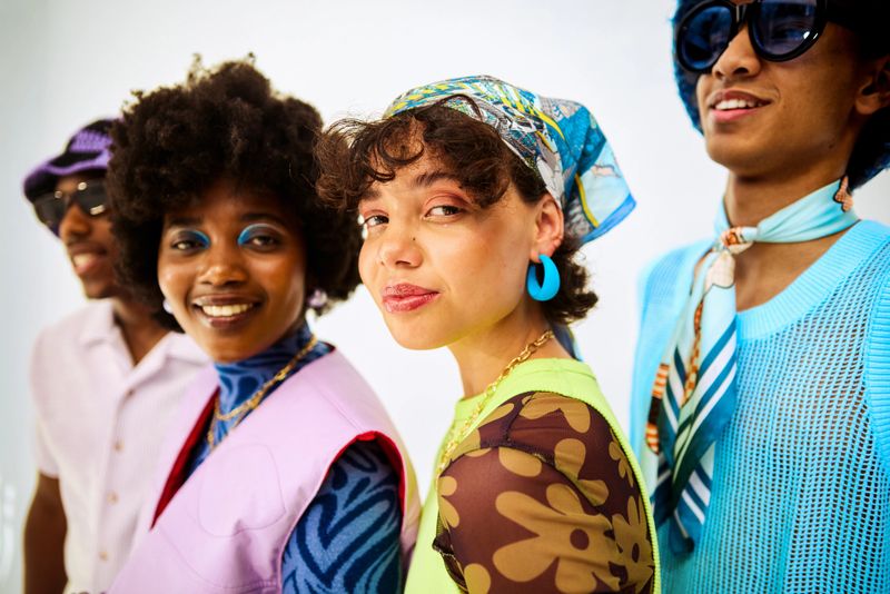 Group of diverse generation z friends posing in colorful outfits, celebrating unique style