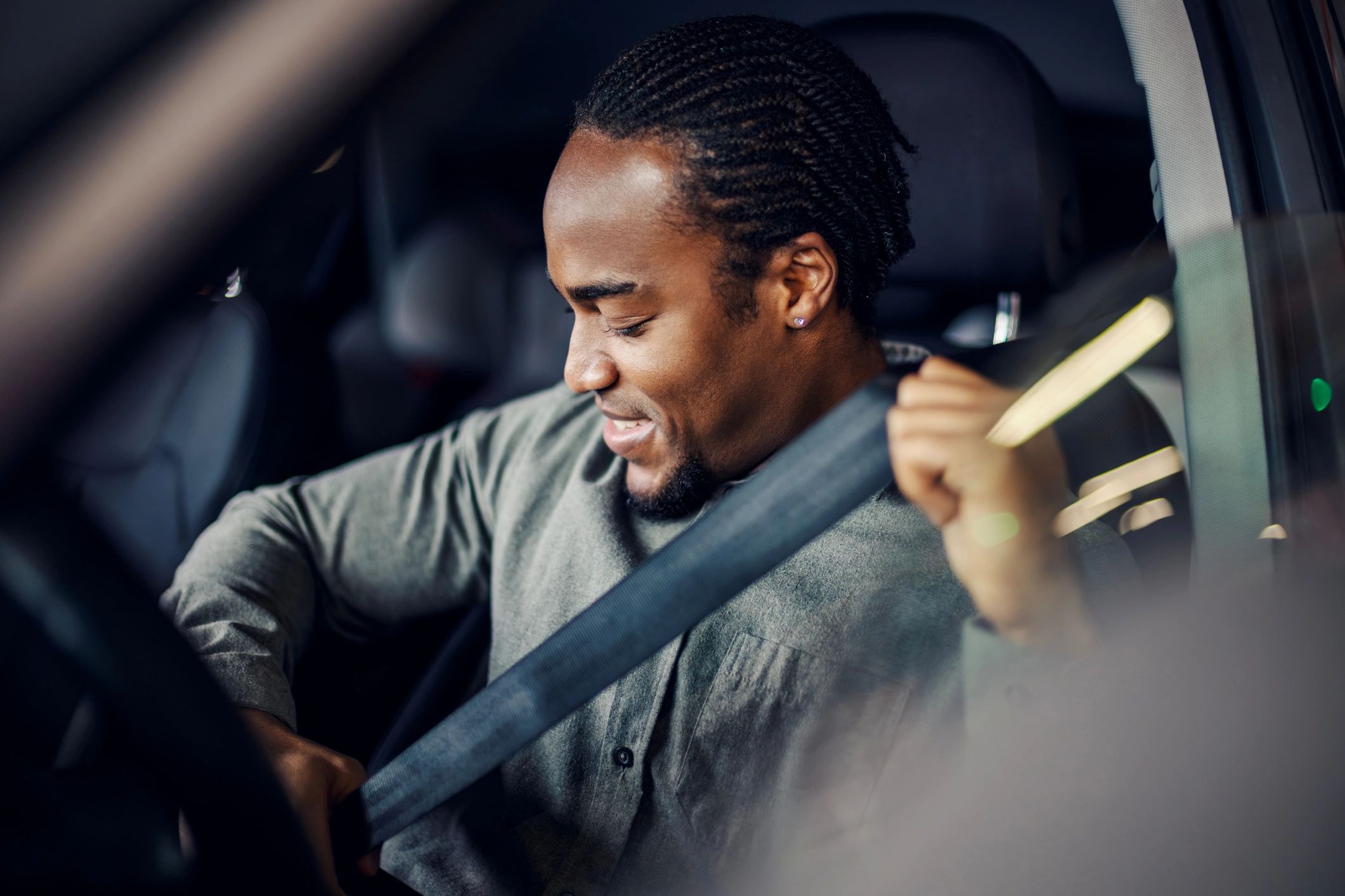 Man putting on seatbelt in car.