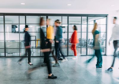 Blurred people walking in a modern office space.