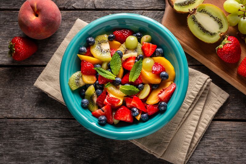 Fruit Salad with Strawberry, Blueberry, Peach, Kiwi Fruit, Green Grapes and Mint Leaves