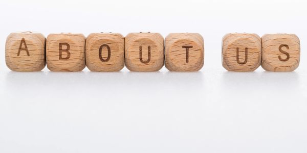 Wooden blocks spelling 'ABOUT US'.