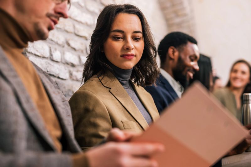 Diverse group of people sitting in an office waiting room before a job interview, showing career opportunity, recruitment process, and professional business environment.