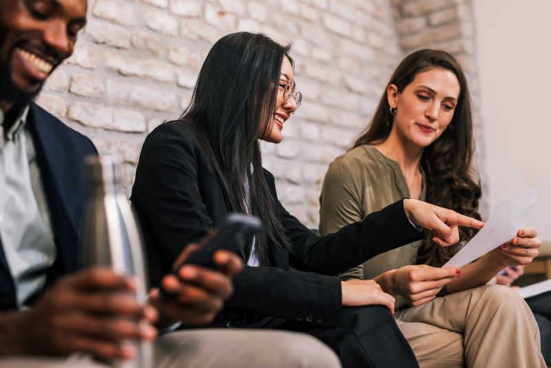 Multicultural group of job candidates waiting in an office interview room, highlighting diversity, inclusion, teamwork, and modern corporate culture.