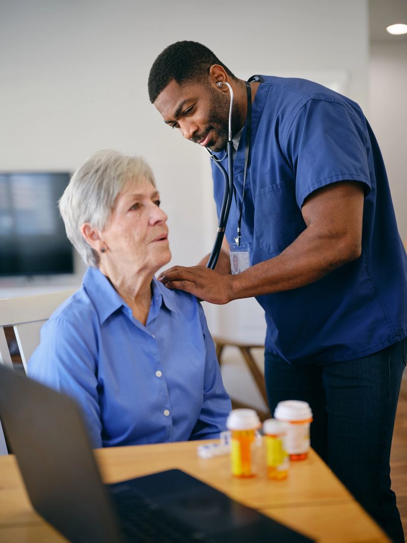 A home health provider attending to a senior aged woman patient in her home.