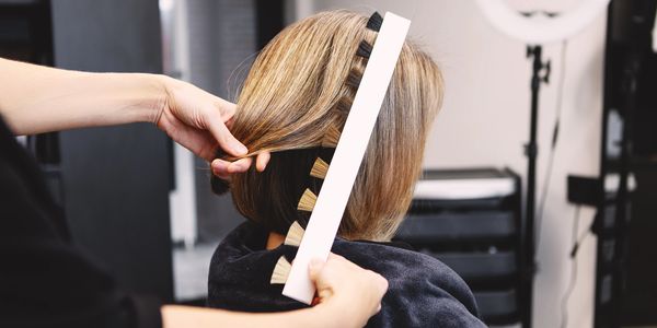 Person getting a hair measurement at a salon.