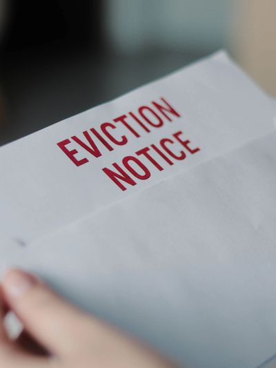 Close-up of a hand holding an eviction notice letter.