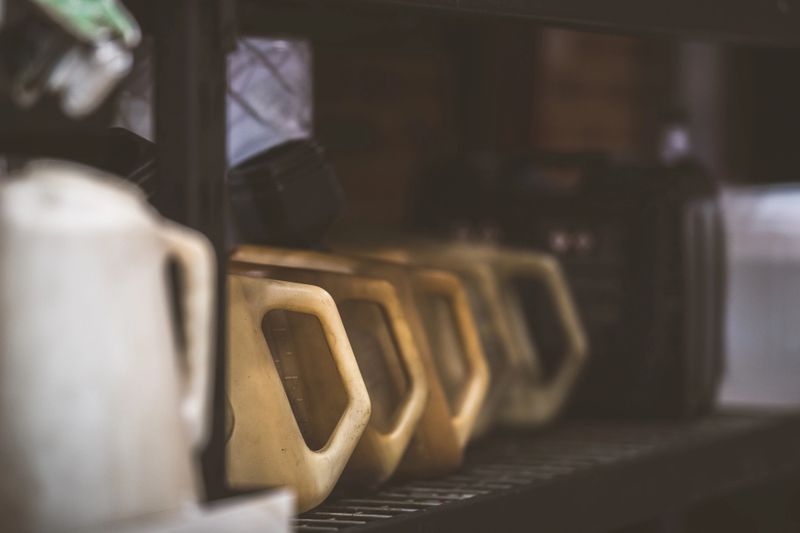 The yellow containers are lined up on a shelf, suggesting organization and preparedness for automotive maintenance