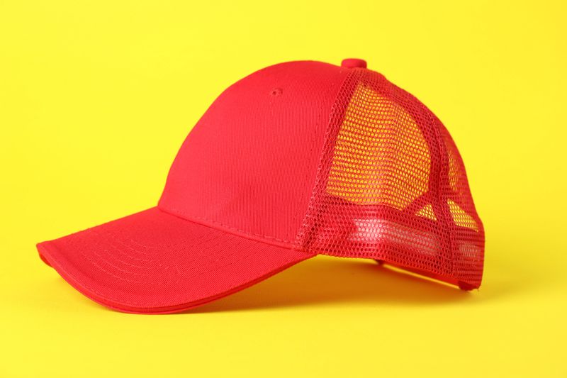 One red baseball cap on yellow background, closeup. Mockup for design