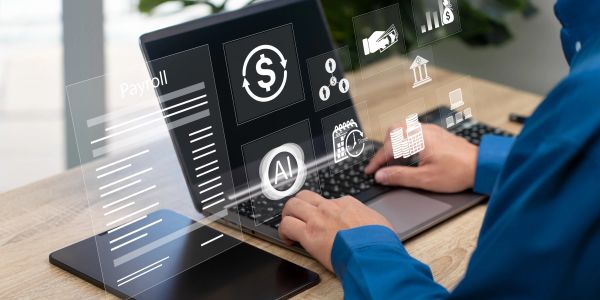 Person using laptop with payroll and AI interface graphics.