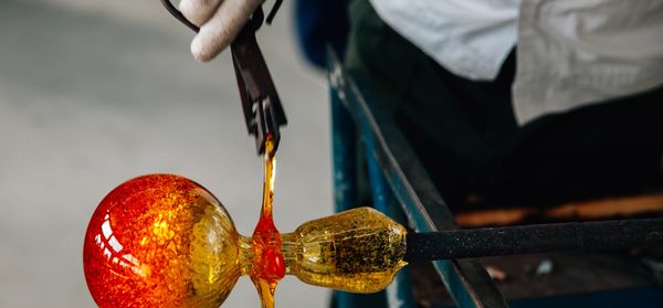 Crafting a glass object with glowing molten glass.