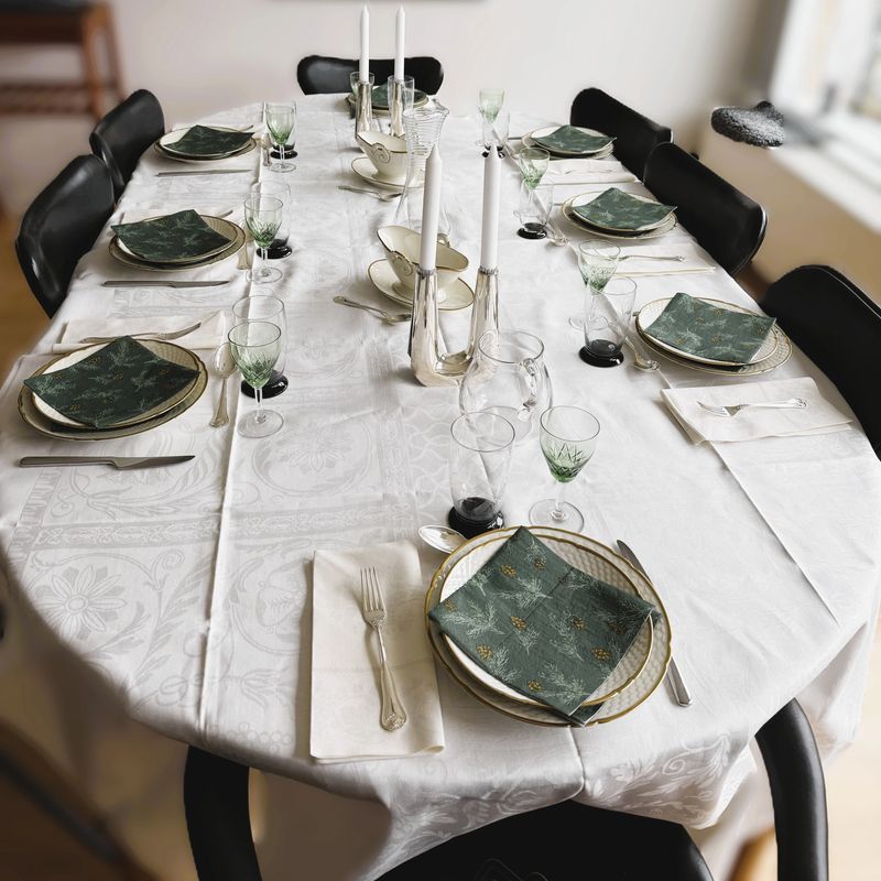 Elegant Scandinavian dining table set for eight in a cozy Nordic interior. Minimalist tableware, neutral tones, and candles placed and ready to be lit create a warm and inviting atmosphere. No people and no food, offering clean copy space and versatility for lifestyle, home decor, hospitality, and interior design concepts.