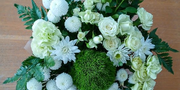 Elegant bouquet with white flowers and lush green foliage.
