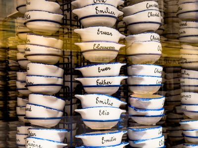 Stacked ceramic bowls with handwritten names in blue ink.