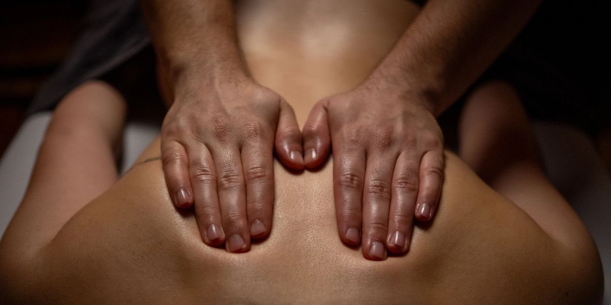 Hands giving a back massage.