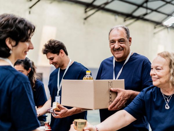 Group of volunteers packing food donations in boxes.