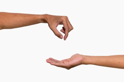 One hand pinching fingers above an open palm of another hand.
