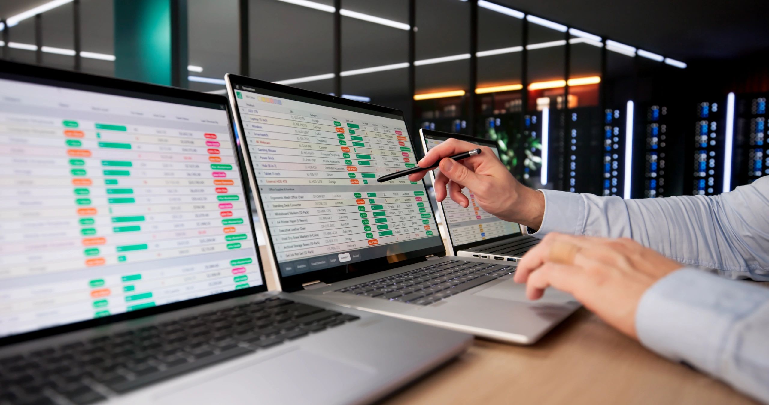 Two laptops display detailed spreadsheet data