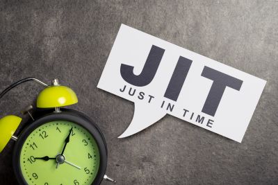 A green alarm clock shows 10:10 next to a card reading 'JIT Just In Time'.