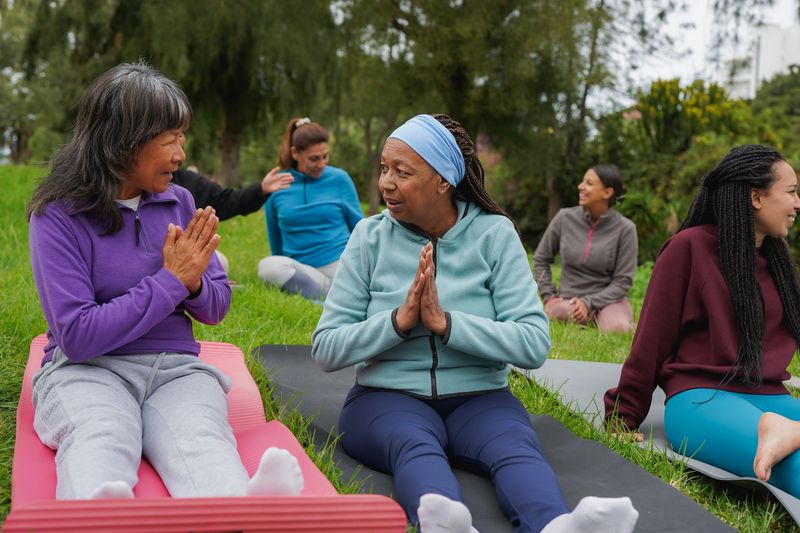 Happy multiracial women circle having fun together outdoor - Community, international female group and multi generational people concept