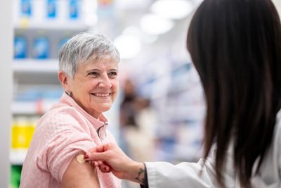 Senior woman receiving a vaccine shot.