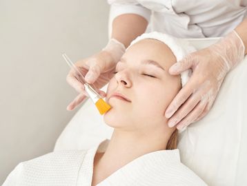Woman receives facial treatment.