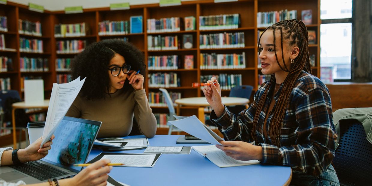 Three students studying together in a library.