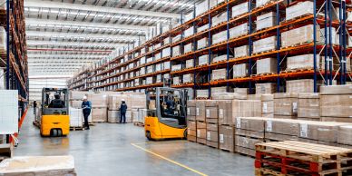 Warehouse with organized shelves and forklifts.
