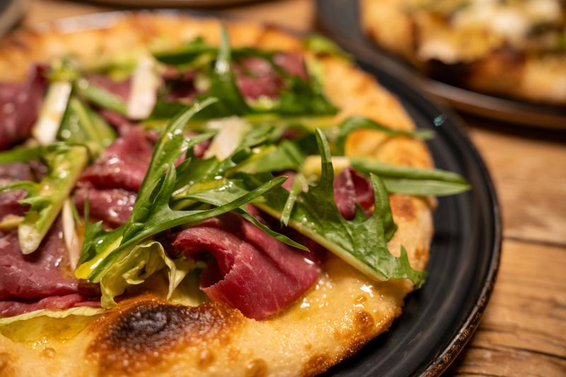 Delicious freshly baked pizza served on table ready to eat with toppings and cheese.