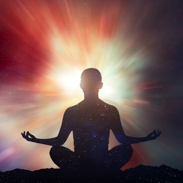 Person meditating with cosmic background and radiant light.