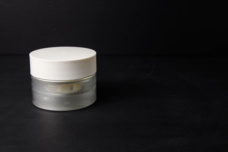 Minimal cosmetic jar on dark background with large copy space, product packaging mockup for skincare.