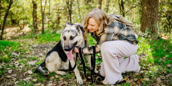 lady in the woods with a german shepherd