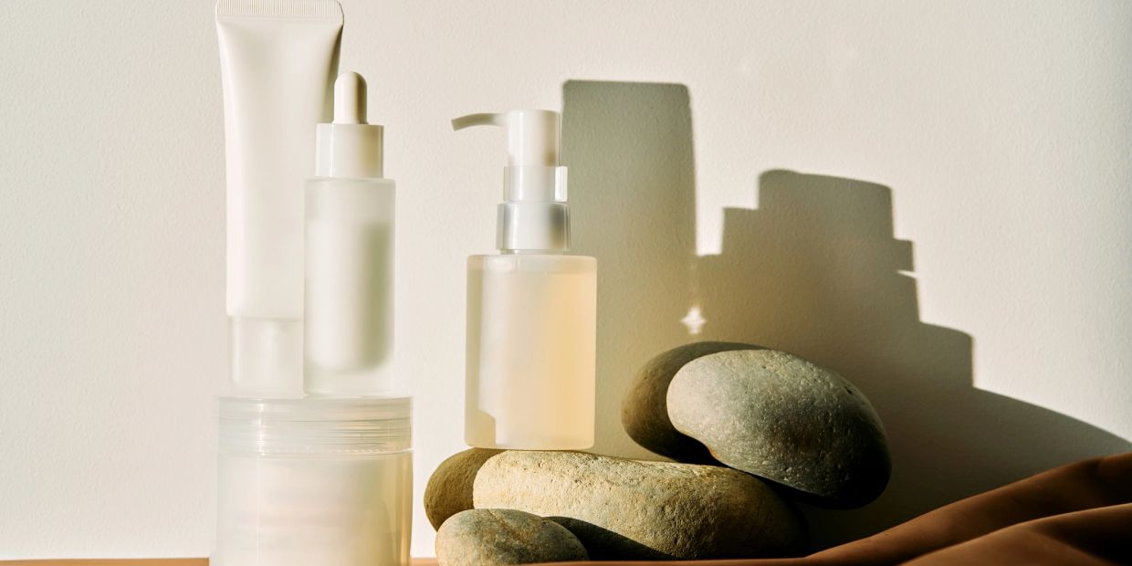 Minimalist skincare products with natural stones and soft sunlight.