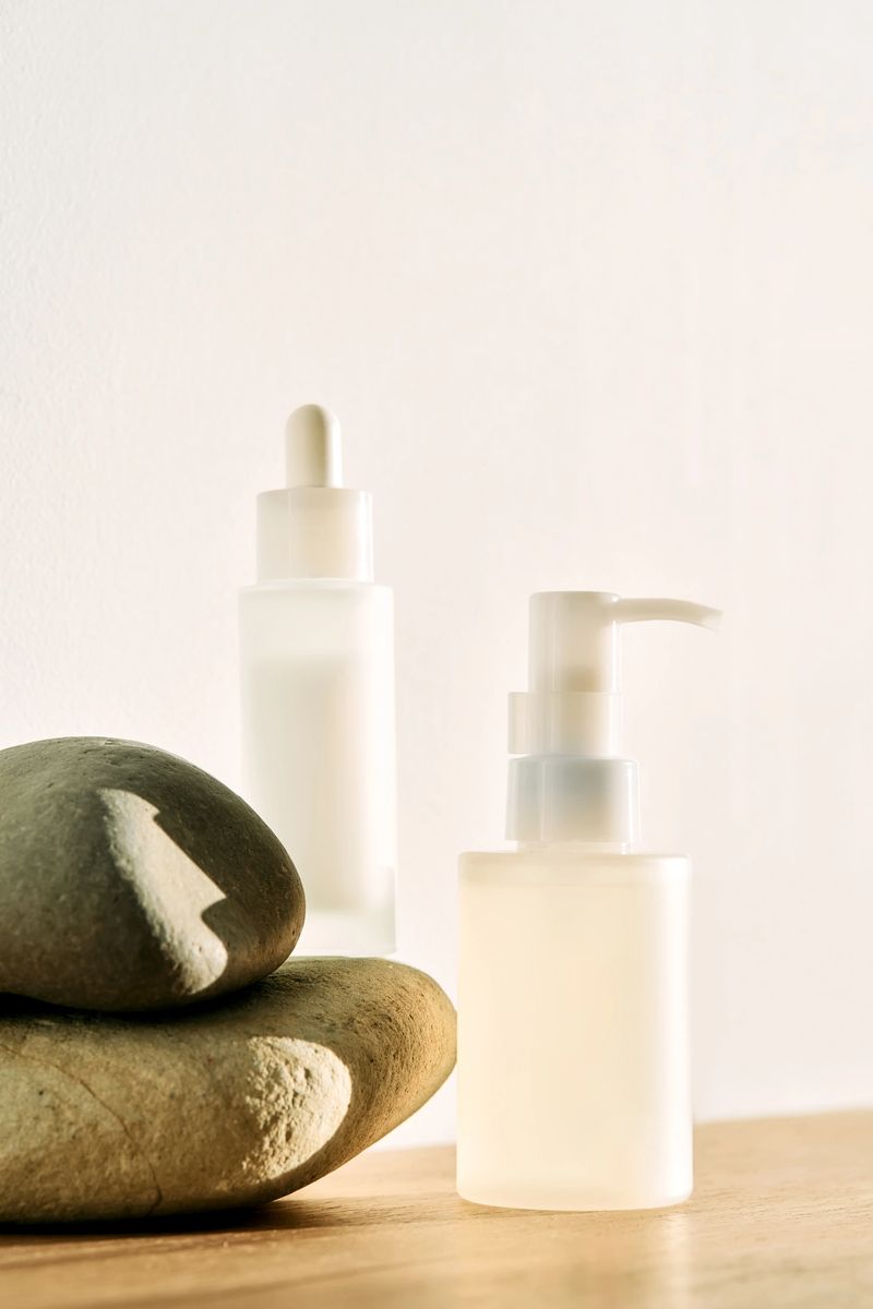 Skincare bottles and natural pebbles creating a tranquil and minimalist wellness scene at home with morning light