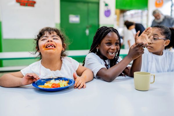 Children enjoying a meal and smiling together.