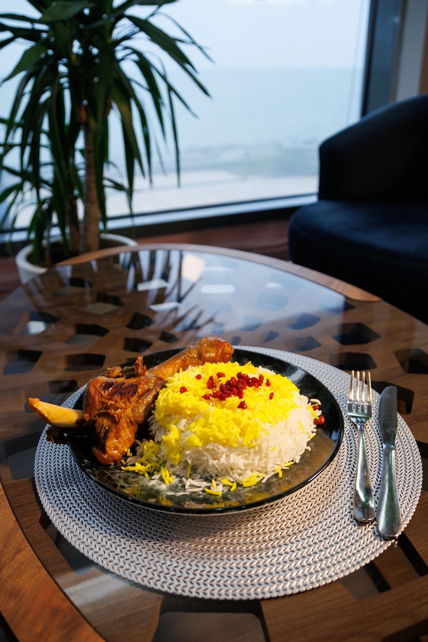 Crispy tahdig layered over saffron rice with chicken in a tray and fresh saffron harvest
