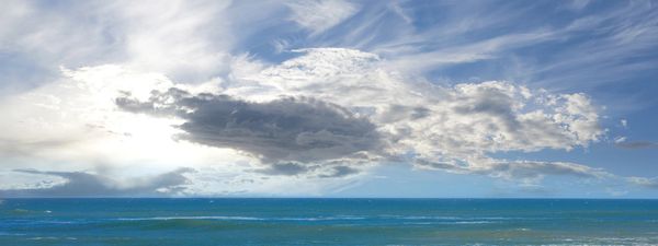 Rocky coastline with blue sky and clouds.