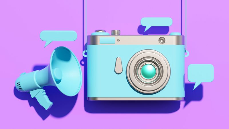 This Digitally Generated Image features a stylized blue Camera - Photographic Equipment hanging next to a Megaphone and floating Speech Bubble icons, set against a vibrant purple background. The 3D Illustration symbolizes the intersection of Photography, Marketing, and Broadcasting. It effectively illustrates Social Media Marketing, Announcement campaigns, and Promotion - Employment strategies. The Modern and Abstract Design with Pastel Colored tones makes it ideal for Business, Advertising, and Communication themes, representing Voice, Feedback, and the spread of Ideas. The clean composition offers ample Copy Space for text, suitable for News Event promotions or Content Creation visuals.