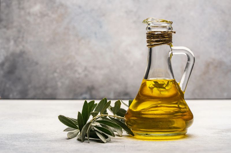 Organic olive oil in jug on stone table