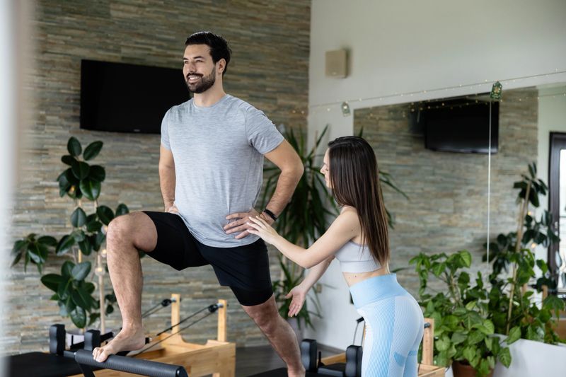 Cheerful fitness partners share playful moments and encouragement while practicing their pilates routine.