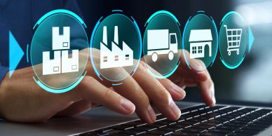 Fingers typing on a keyboard with supply chain icons.