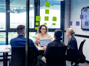 Team discussing strategies in a bright office meeting.