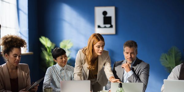 Team reviewing business operations together around a laptop
