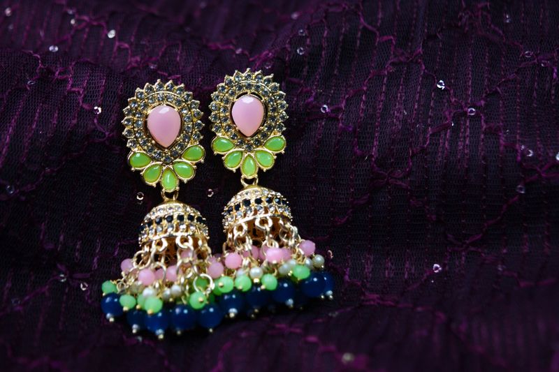 Vintage style indian earring on fabric background