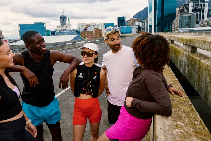 Diverse group of friends smiling, enjoying a social gathering after a morning run