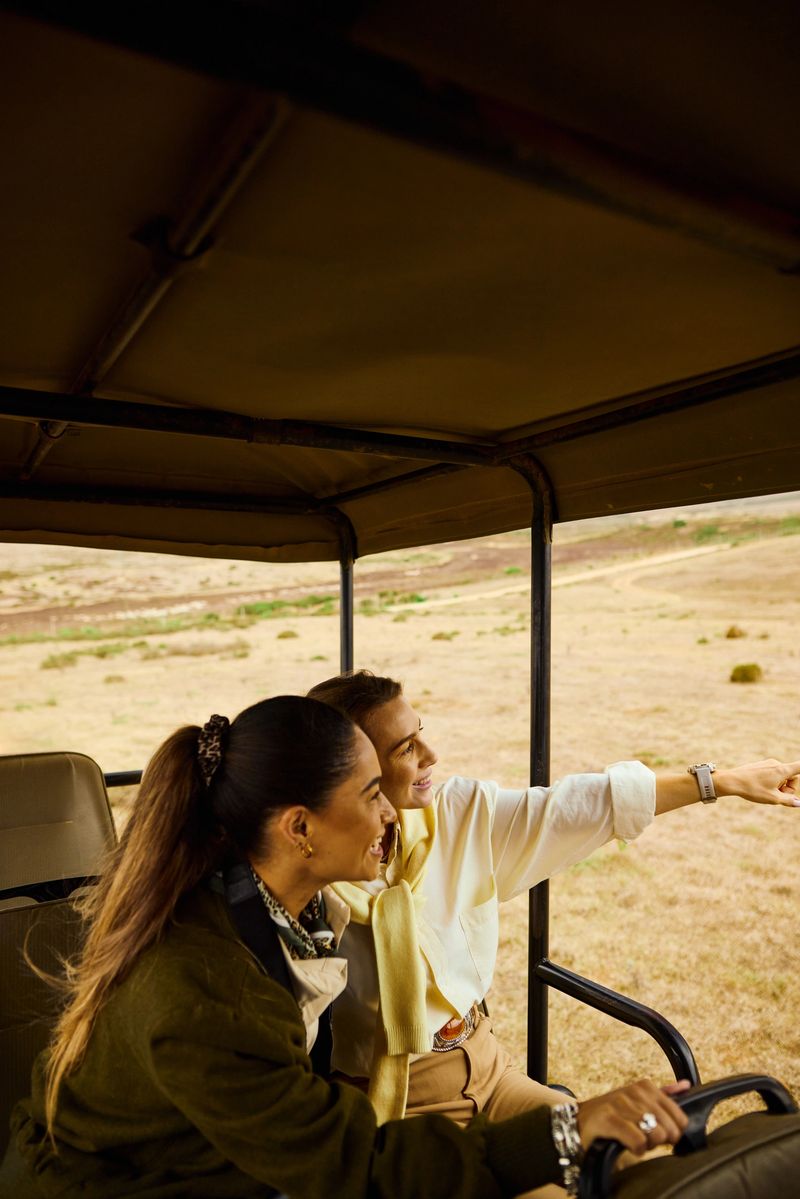 Two adult women enjoying an experiential eco-tourism safari ride in a jeep