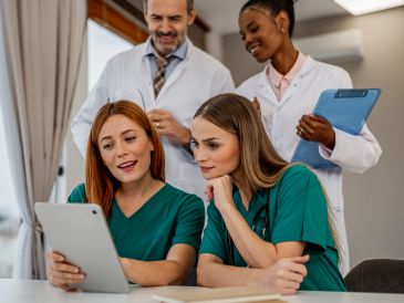 Healthcare professionals reviewing patient data on a tablet.